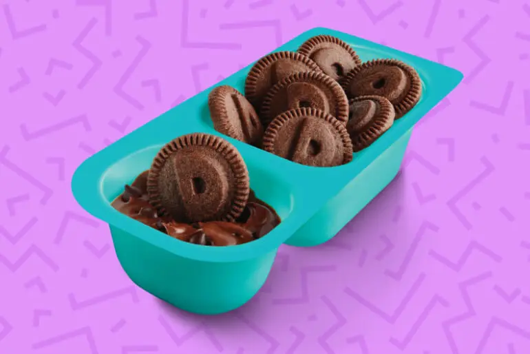 A open pack of Chocolate Dunkaroos with Chocolate Frosting on a purple background with pink squiggly lines